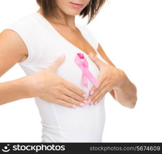 healthcare and medicine concept - woman in blank t-shirt with pink breast cancer awareness ribbon checking breast