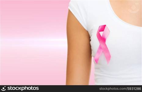 healthcare and medicine concept - woman in blank t-shirt with pink breast cancer awareness ribbon. woman with pink cancer awareness ribbon
