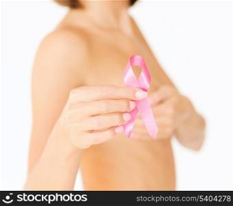 healthcare and medicine concept - womans hand holding pink breast cancer awareness ribbon