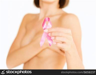 healthcare and medicine concept - womans hand holding pink breast cancer awareness ribbon