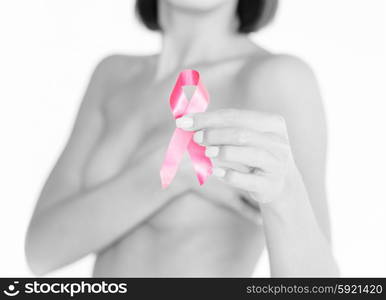 healthcare and medicine concept - womans hand holding pink breast cancer awareness ribbon. hand holding pink breast cancer awareness ribbon