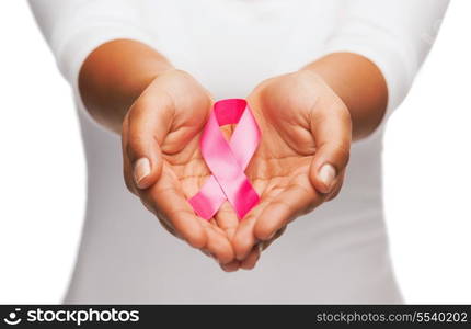 healthcare and medicine concept - womans hands holding pink breast cancer awareness ribbon