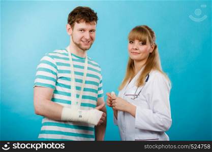 Healthcare and protection. Young man with broken hand sprained wrist visit female doctor. Specialist with bandage.. Man with broken hand visit doctor.