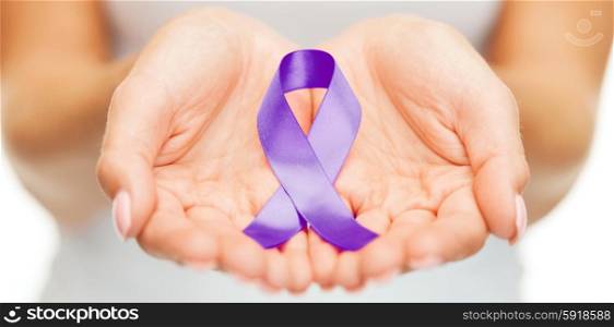 healthcare and social problems concept - womans hands holding purple domestic violence awareness ribbon. hands holding purple awareness ribbon