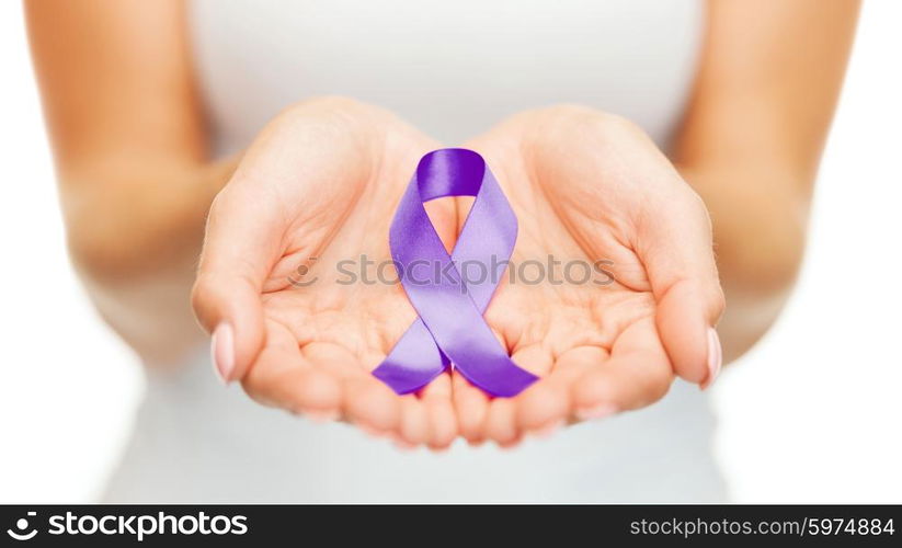 healthcare and social problems concept - womans hands holding purple domestic violence awareness ribbon. hands holding purple awareness ribbon