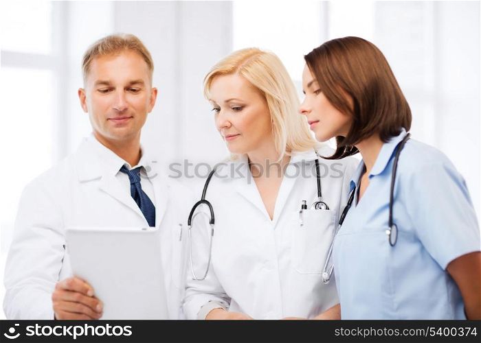 healthcare and technology concept - doctors looking at tablet pc