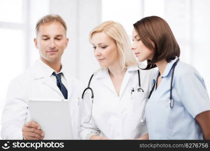 healthcare and technology concept - doctors looking at tablet pc