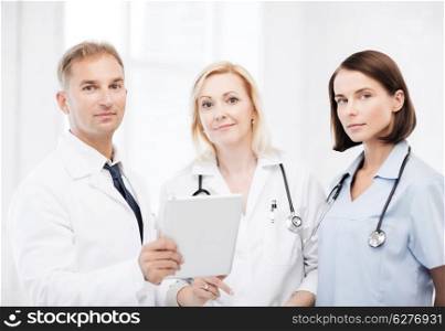 healthcare and technology concept - doctors looking at tablet pc
