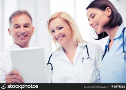 healthcare and technology concept - doctors looking at tablet pc. doctors looking at tablet pc