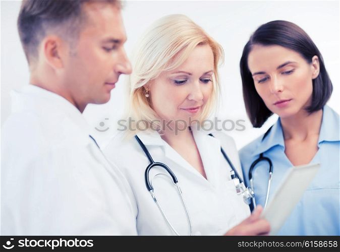 healthcare and technology concept - doctors looking at tablet pc. doctors looking at tablet pc