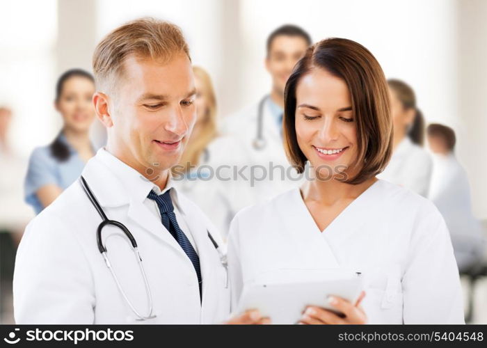 healthcare and technology concept - two doctors looking at tablet pc