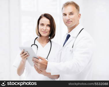 healthcare and technology concept - two doctors looking at tablet pc