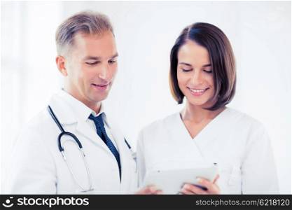 healthcare and technology concept - two doctors looking at tablet pc. two doctors looking at tablet pc