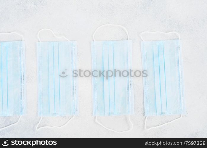 Healthcare and virus protection concept - virus protection mask row laying on the table. Healthcare concept on blue