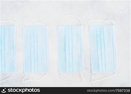 Healthcare and virus protection concept - virus protection mask row laying on the table. Healthcare concept on blue