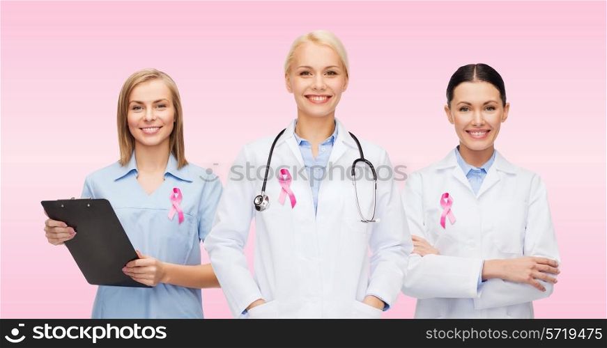 healthcare, charity, support and medicine concept - group of female doctors with pink breast cancer awareness ribbon