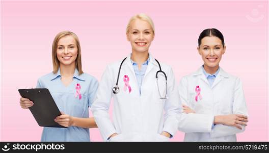 healthcare, charity, support and medicine concept - group of female doctors with pink breast cancer awareness ribbon