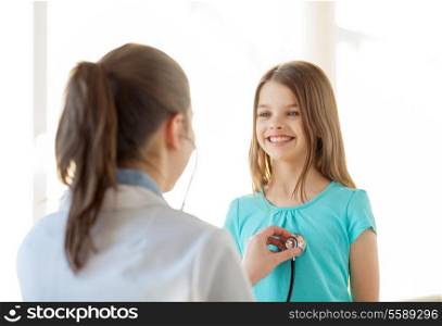 healthcare, child and medical concept - female doctor with stethoscope listening to child chest in hospital