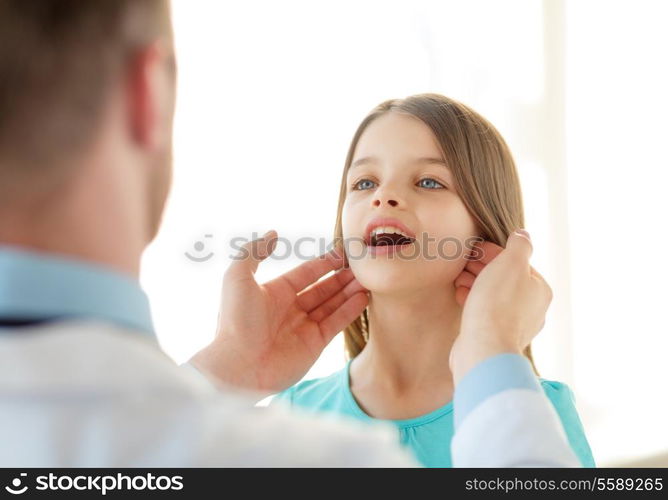 healthcare, child and medical concept - male doctor checks little girl lymph nodes in hospital