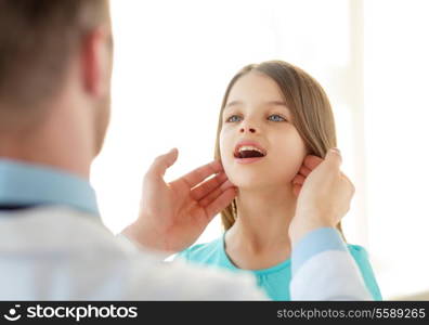 healthcare, child and medical concept - male doctor checks little girl lymph nodes in hospital