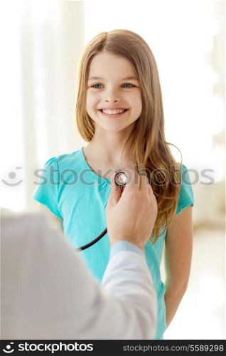 healthcare, child and medical concept - male doctor with stethoscope listening to child chest in hospital