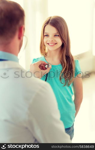 healthcare, child and medical concept - male doctor with stethoscope listening to child chest in hospital