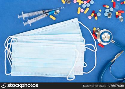 Healthcare concept - stethoscope, masks and pills on blue , corona viruses concept. Healthcare concept on blue