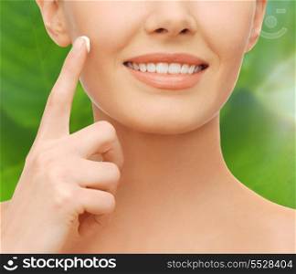 healthcare, cosmetics and beauty concept - closeup of woman hand applying moisturizing cream