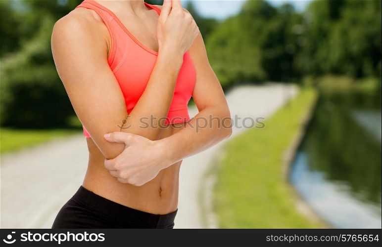 healthcare, fitness and medicine concept - sporty woman with pain in elbow