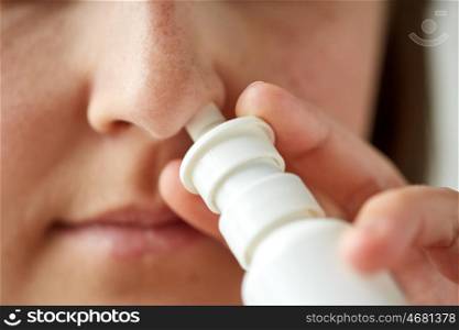 healthcare, flu, rhinitis, medicine and people concept - close up of sick woman using nasal spray