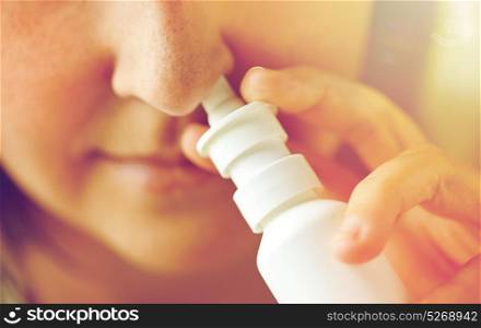healthcare, flu, rhinitis, medicine and people concept - close up of sick woman using nasal spray. close up of sick woman using nasal spray