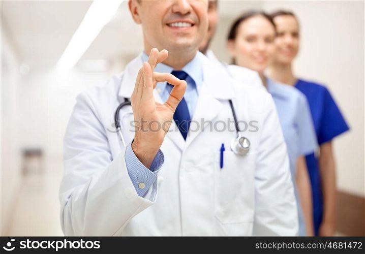 healthcare, gesture, people and medicine concept - close up of happy doctors at hospital showing ok hand sign