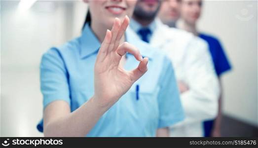 healthcare, gesture, people and medicine concept - close up of happy doctors at hospital showing ok hand sign. close up of doctors at hospital showing ok sign