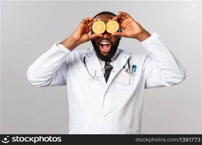 Healthcare, healthy diet and disease concept. Wow so many vitamins. Portrait of amazed happy african-american doctor ask self-distance and eat more vitamins, hold oranges like eyes.. Healthcare, healthy diet and disease concept. Wow so many vitamins. Portrait of amazed happy african-american doctor ask self-distance and eat more vitamins, hold oranges like eyes