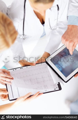 healthcare, hospital and medical concept - group of doctors looking at x-ray on tablet pc