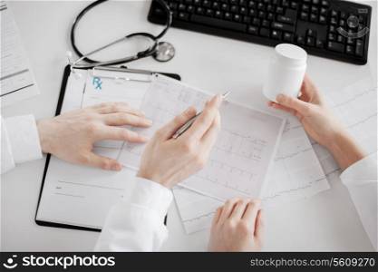 healthcare, hospital and medical concept - two doctors prescribing medication