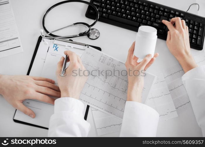 healthcare, hospital and medical concept - two doctors prescribing medication