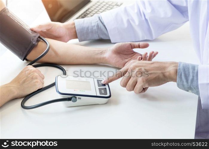 healthcare, hospital and medicine concept - doctor and patient measuring blood pressure.