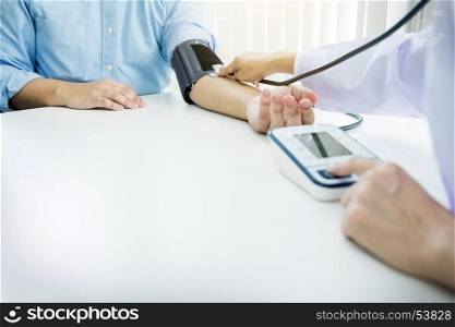 healthcare, hospital and medicine concept - doctor and patient measuring blood pressure