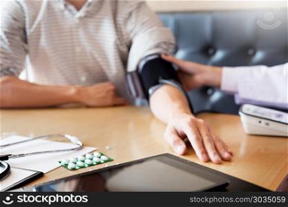 healthcare, hospital and medicine concept - doctor and patient measuring blood pressure by machine.. healthcare, hospital and medicine concept - doctor and patient m
