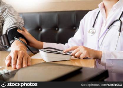 healthcare, hospital and medicine concept - doctor and patient measuring blood pressure by machine.. healthcare, hospital and medicine concept - doctor and patient m