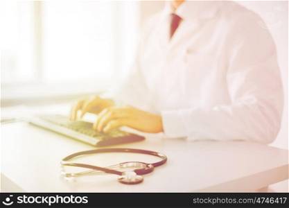 healthcare, hospital and medicine concept - male doctor typing on the keyboard