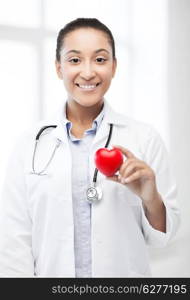 healthcare, medical and cardiology concept - african female doctor with heart