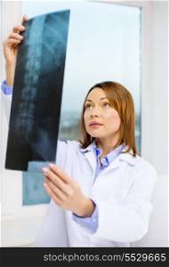 healthcare, medical and radiology concept - concentrated doctor looking at x-ray