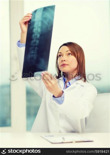 healthcare, medical and radiology concept - concentrated doctor looking at x-ray