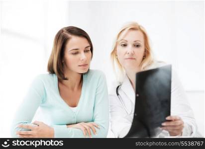 healthcare, medical and radiology concept - doctor with patient looking at x-ray