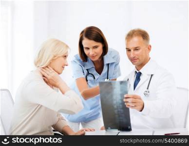 healthcare, medical and radiology concept - doctors with patient looking at x-ray