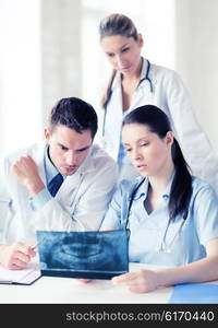 healthcare, medical and radiology concept - group of doctors looking at x-ray