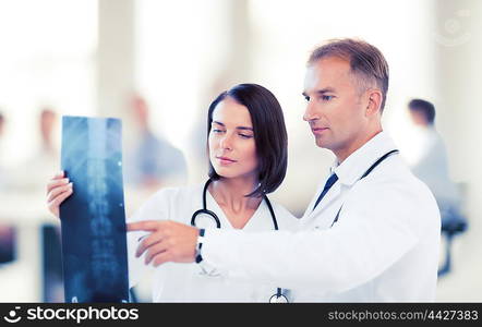 healthcare, medical and radiology concept - two doctors looking at x-ray