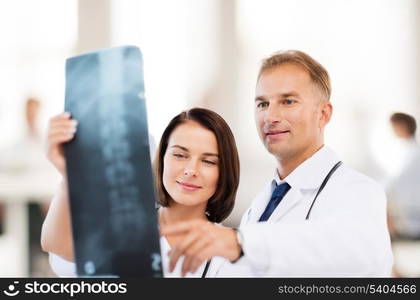 healthcare, medical and radiology concept - two doctors looking at x-ray